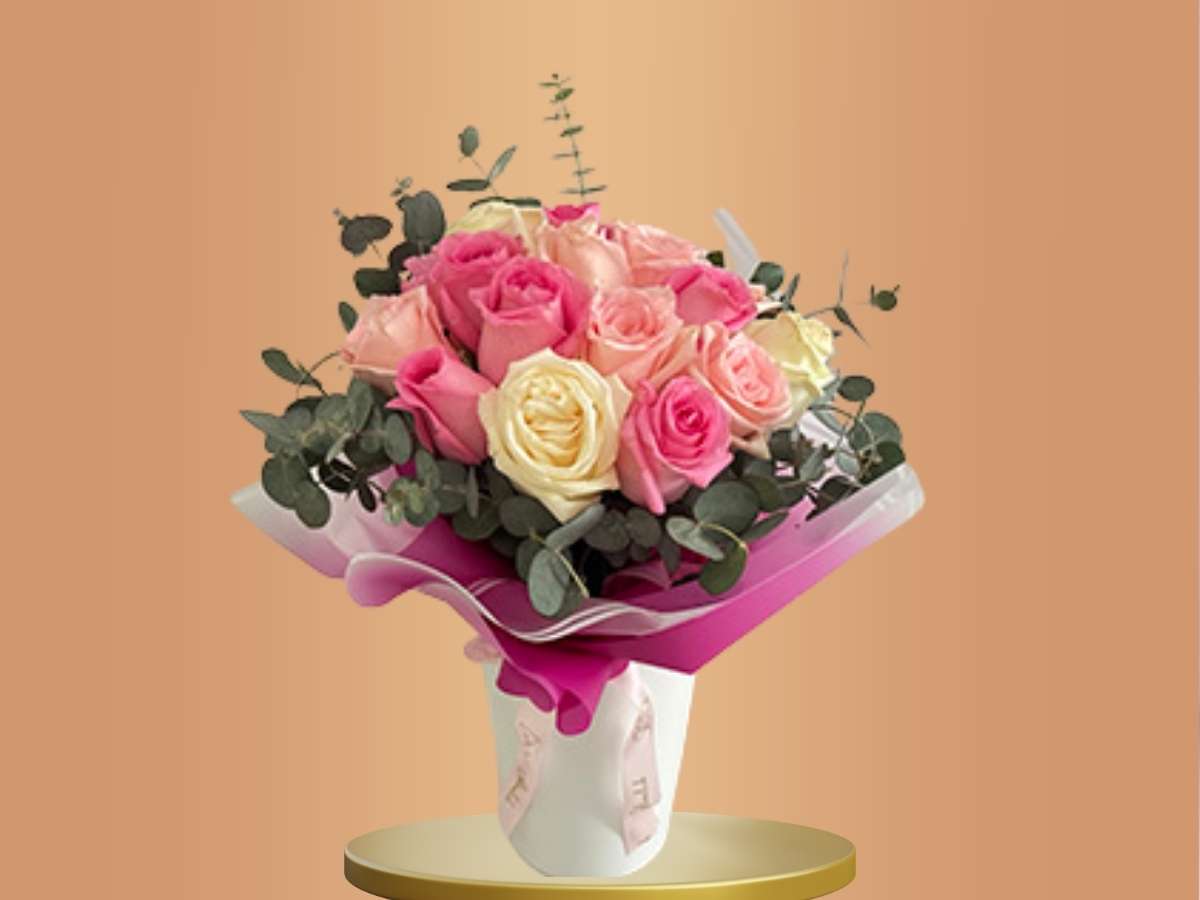 Bouquet of pink and white roses with greenery on a beige background