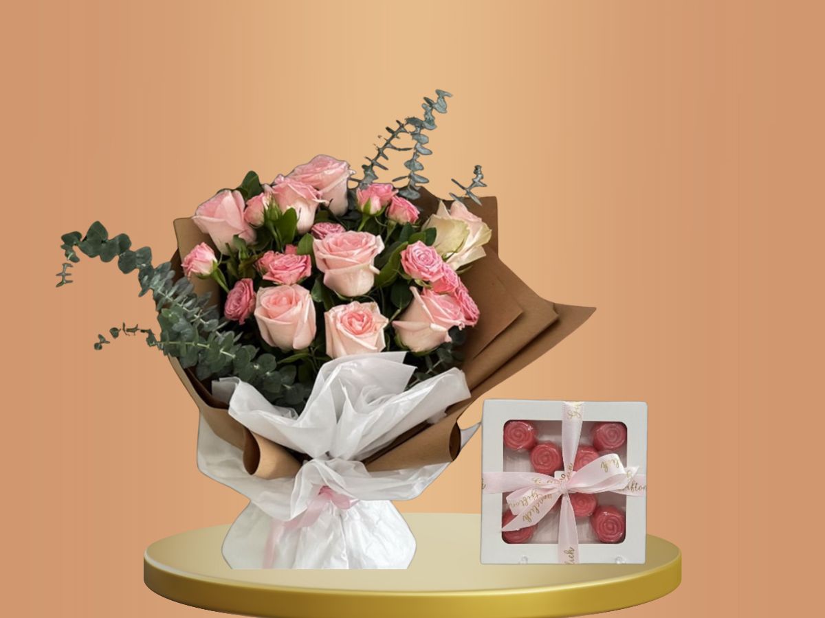 Bouquet of flowers and a box of chocolates on a peach background