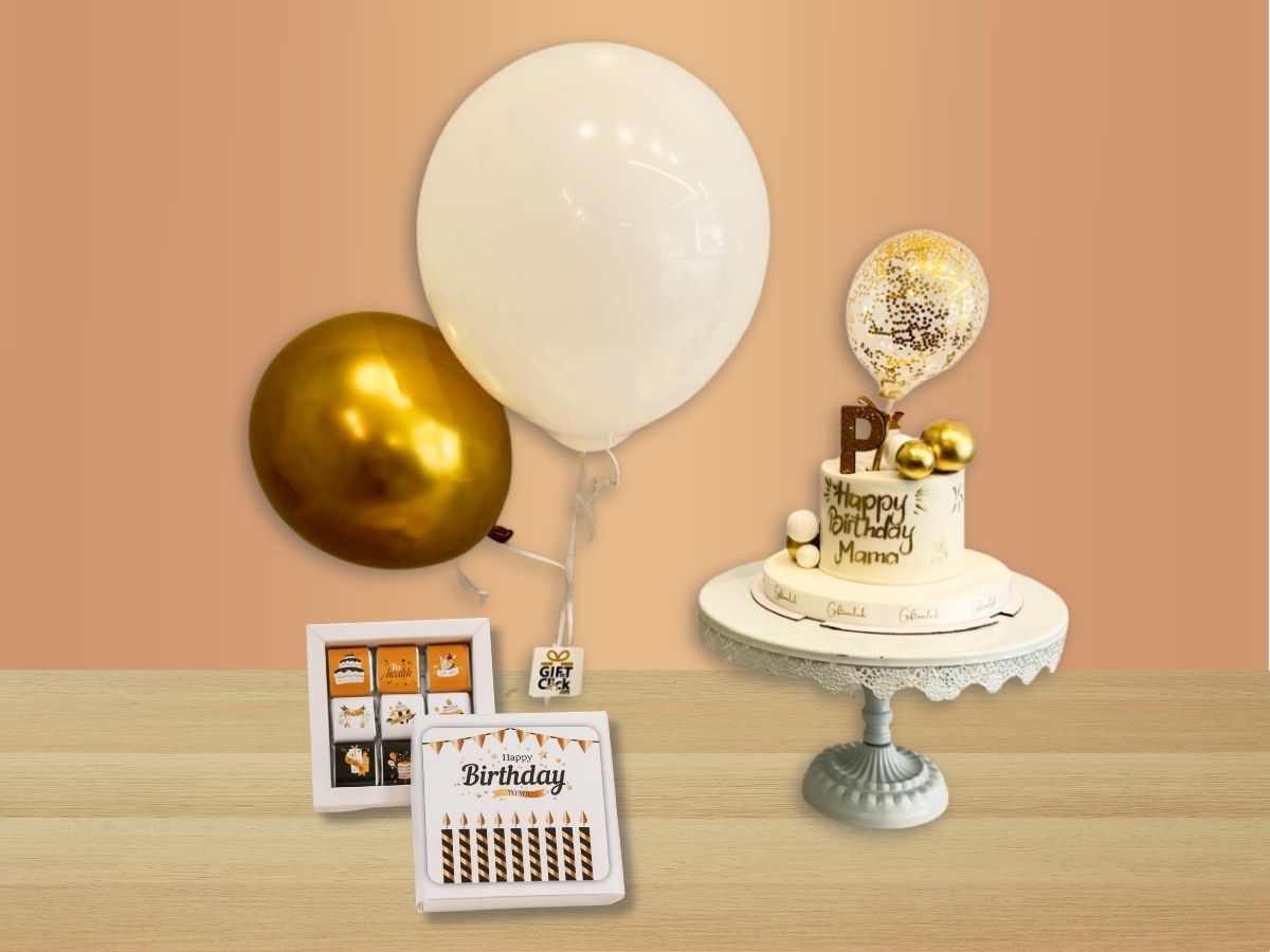 Golden birthday gift bundle featuring a white cake with gold decorations, gold and white balloons, and one box of birthday chocolates.

