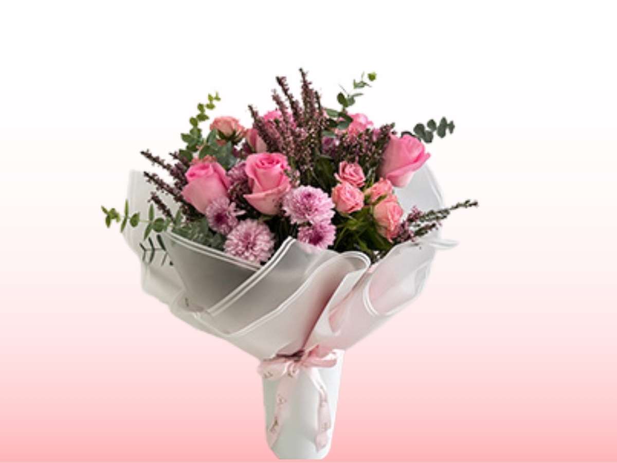 Bouquet of pink and purple flowers in a white container on a gradient background