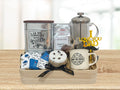 Gift basket with coffee-themed items including a French press, coffee beans, and a mug on a wooden tray.