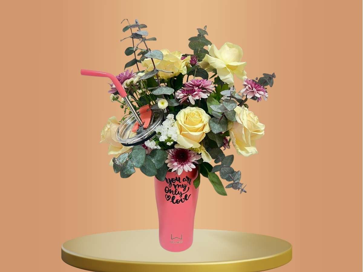 Pink cup with flowers on a round platform against an orange background
