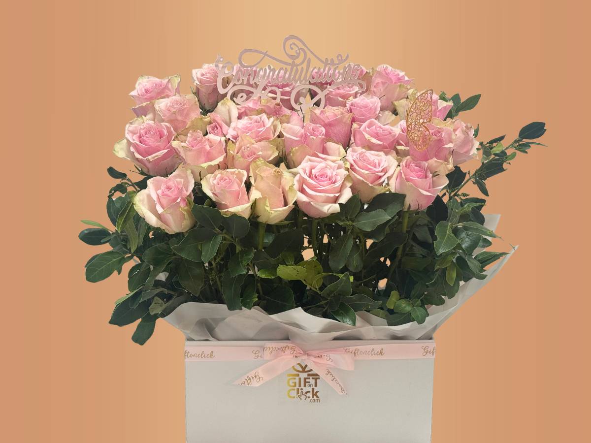 The rose garden box-Arrangement of pink roses in a box with a decorative topper on a peach background-Lebanon