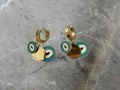 Gold hoop earrings with green and gold circular charms 