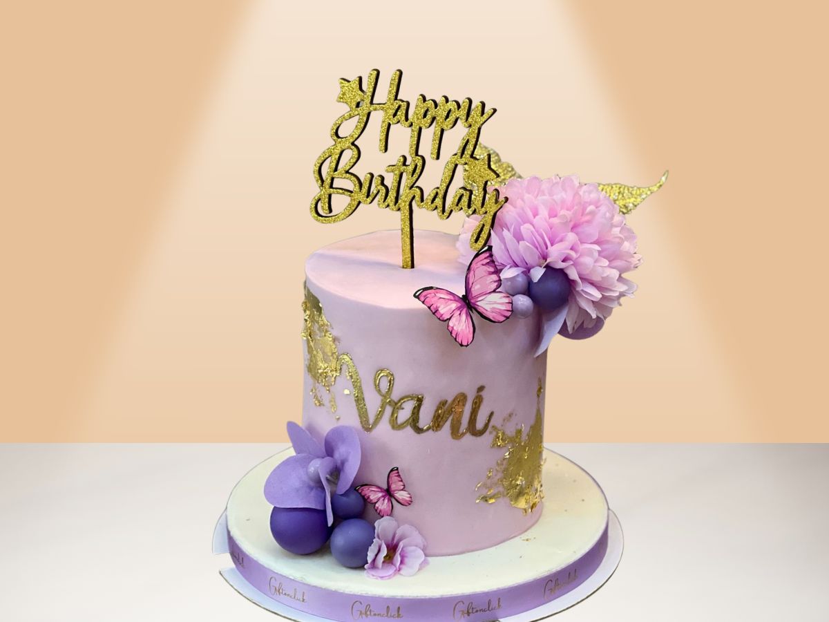 purple cake with birthday topper and flowers