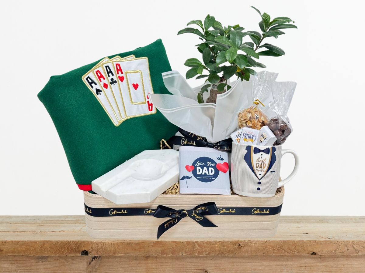 gift with cards round table cover, marble cigar ashtray, a chocolate bar, a Bonsai tree, and a mug filled with chocolate pieces, nuts, and dragee chocolates