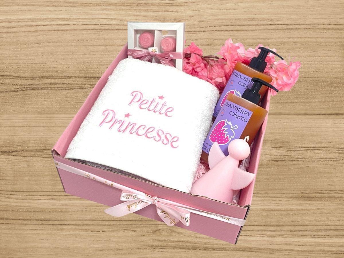 embroidered towel, chocolates, candle and strawberry scented shower gel and shampoo for babies