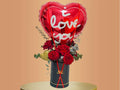 Heart-shaped balloon with 'I love you' text and flowers in a black box
