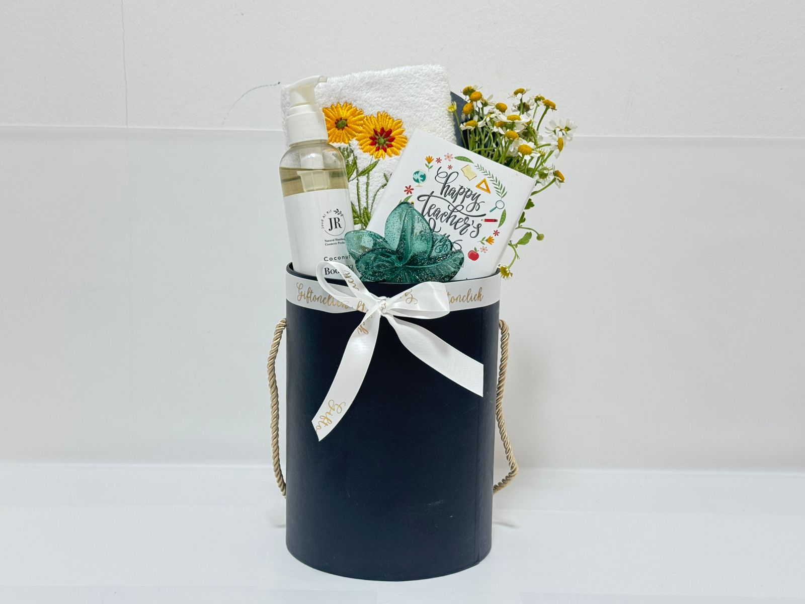 Gift set with a body oil, flowers, hair clip and a chocolate bar