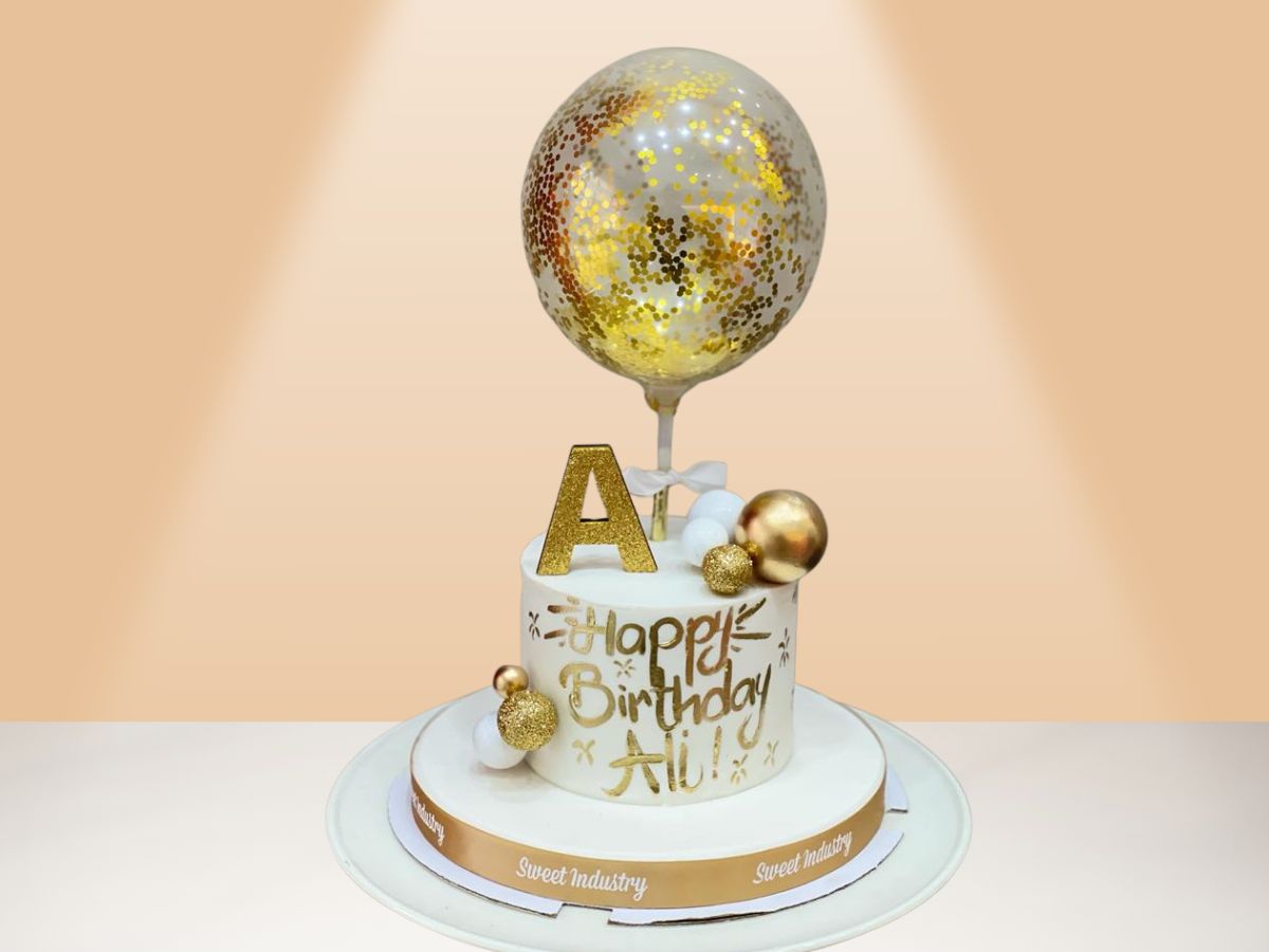 birthday cake with balloon and gold colors